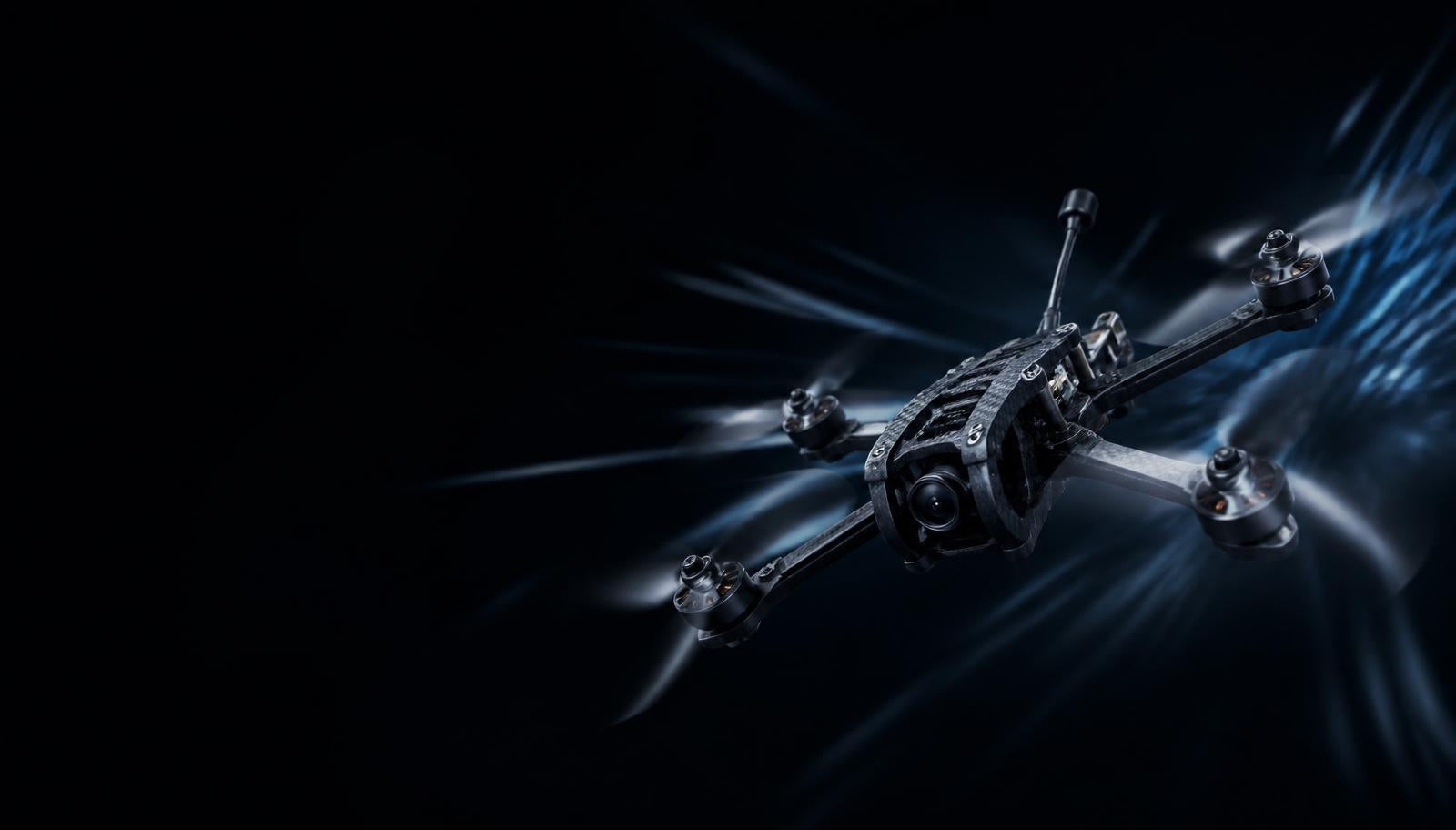 Carbon fibre FPV drone in motion through dark space