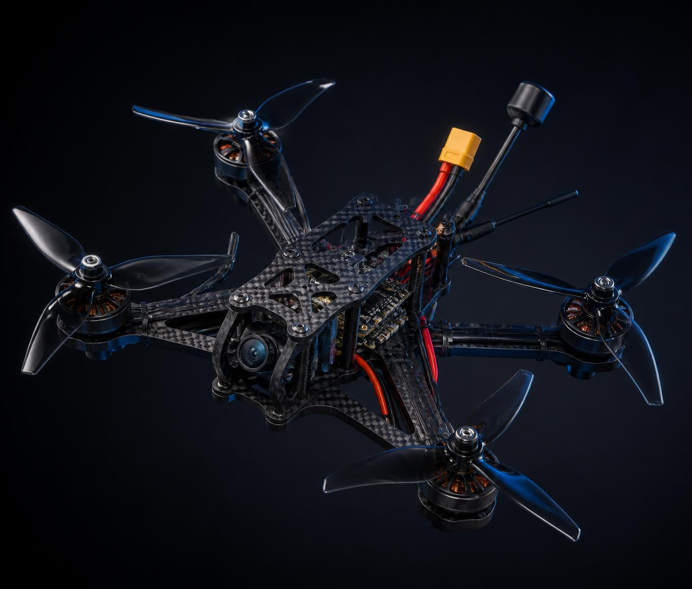 Partially assembled carbon fibre freestyle FPV drone with visible motors, propellers and flight electronics